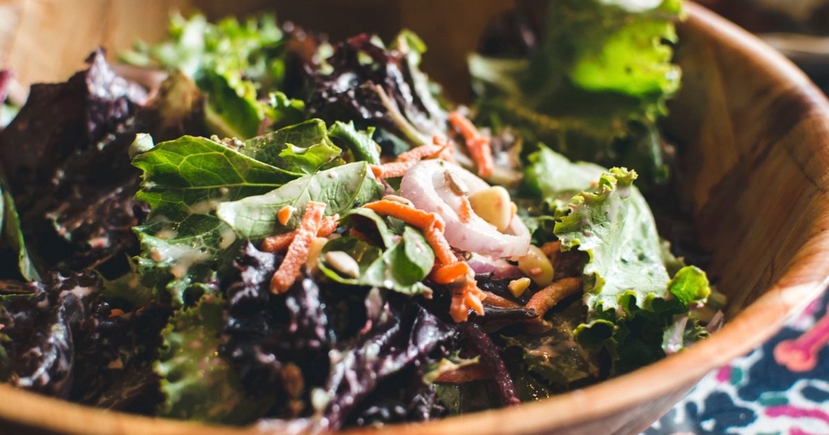 A mixed green salad in a wooden bowl