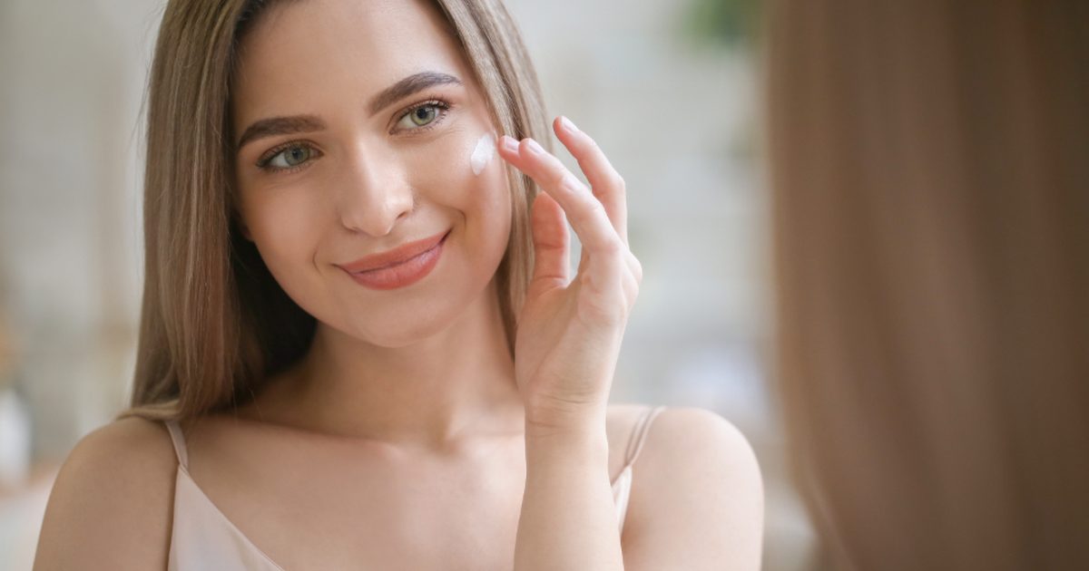 A woman touching her cheek and smiling
