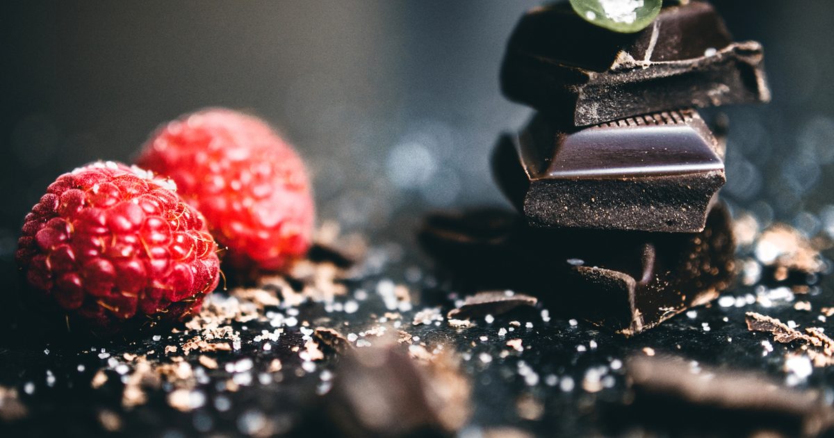 Fresh raspberries beside pieces of dark chocolate