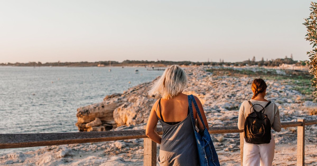 Two women walking on a coastal path in the morning