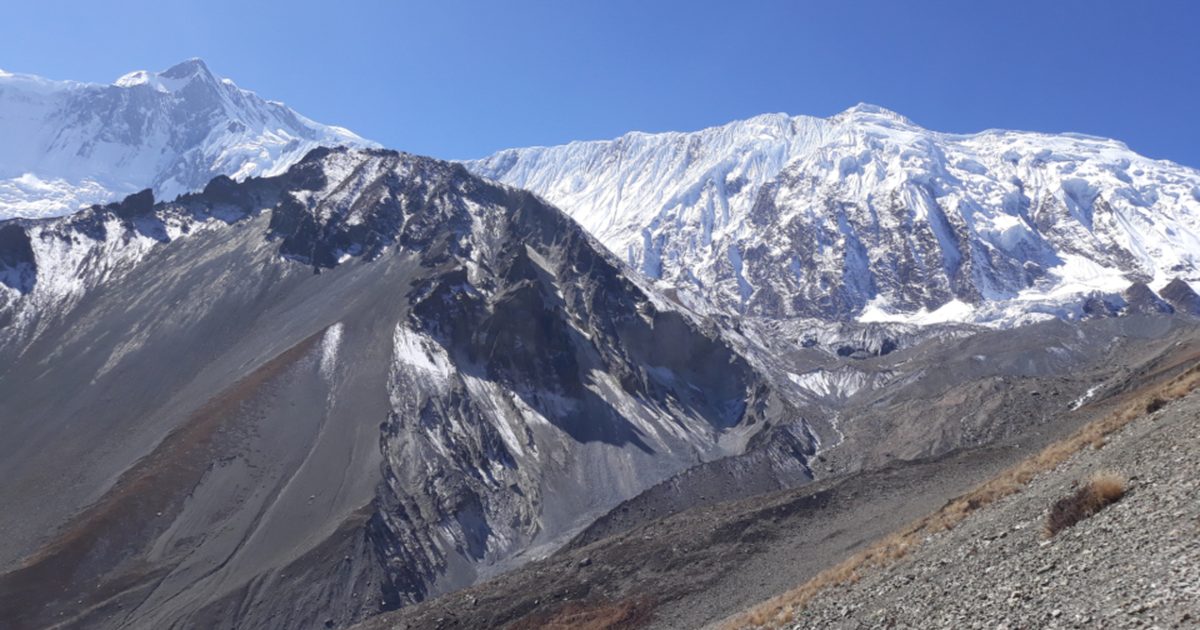 Snow capped Himalayan peaks above a steep rocky valley, where shilajit is gathered