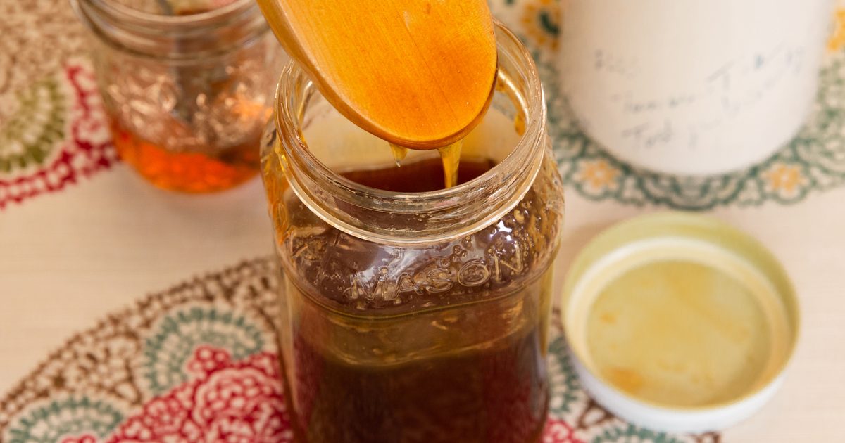 Golden syrup being poured into a glass jar